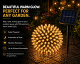 Solar powered decorative light ball with text highlighting features on a garden background