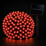 Red string lights with solar panel on a black background