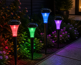 Four solar-powered garden lights in red, green, blue, and purple colors on a garden path.