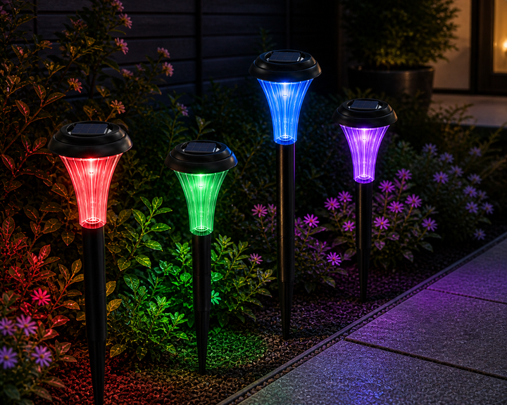 Four solar-powered garden lights in red, green, blue, and purple colors on a garden path.