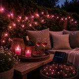 Outdoor evening setting with solar string lights, candles, wine glasses, and a bottle of champagne.